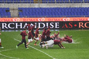 I calciatori della Roma si tuffano sul prato, incitati dai tifosi, al termine della sgambatura chiesta dall'allenatore Rudi Garcia dopo il rinvio di Roma-Parma allo stadio Olimpico (ANSA)