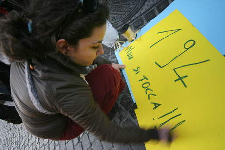 Una donna prepara un piccolo striscione per manifestare in difesa della legge 194, Napoli