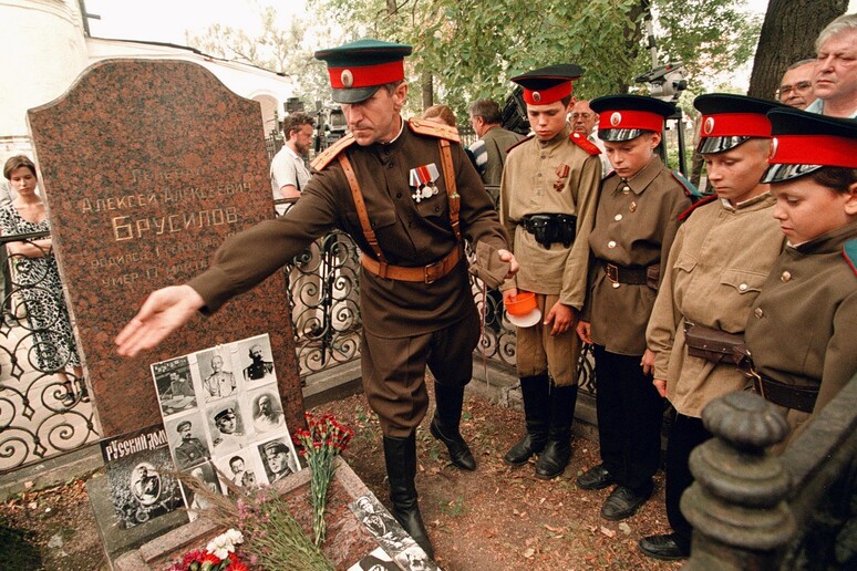 Un insegnante di una scuola militare racconta ai suoi allievi la storia del generale russo Alexdey Brussilov, eroe della prima guerra mondiale durante una visita alla sua tomba nel monastero Novodevichy a Mosca - RIPRODUZIONE RISERVATA